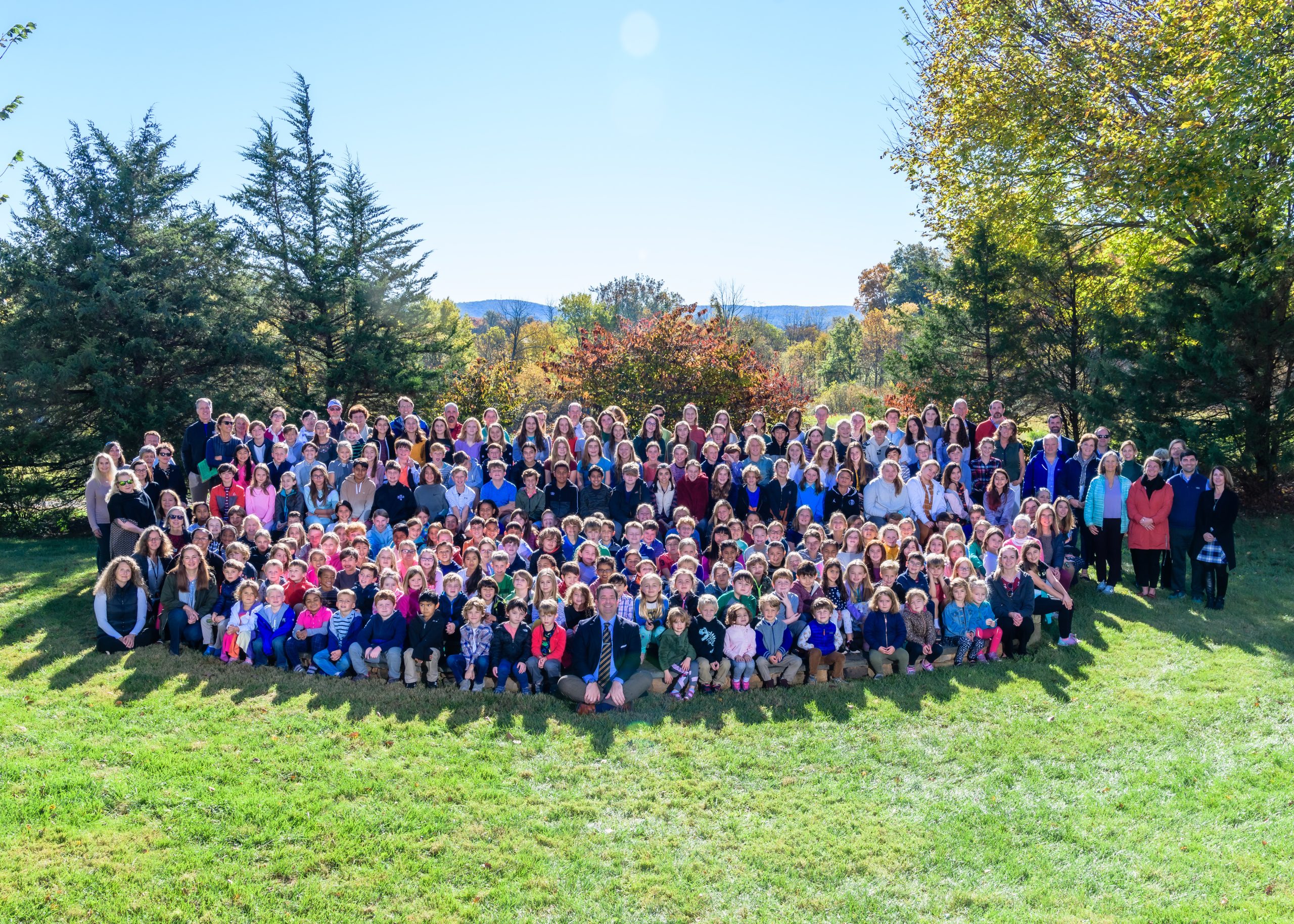 large group of kids posing for photo outside at hill school