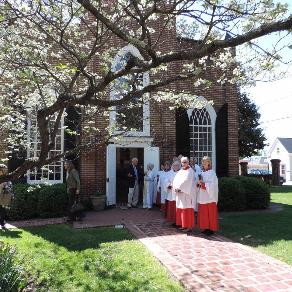 Emmanuel Church photo outside in spring, brick walkway and flowering trees